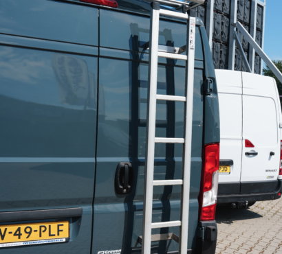 Gebruikte bedrijfswagens van Greven Automotive met ladderrek op het bedrijventerrein.